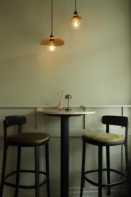 a table and two bar stools in a room at Het Hart van Weesp in Weesp