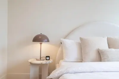 a bed with white pillows and a lamp on a table at Elegant & unique canal house in famous canal area in Amsterdam