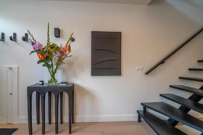 a vase of flowers on a table next to a staircase at Elegant & unique canal house in famous canal area in Amsterdam