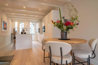 a kitchen and dining room with a wooden table and chairs at Elegant & unique canal house in famous canal area in Amsterdam