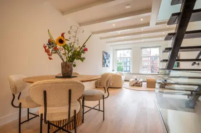 a dining room with a table and chairs with a vase of flowers at Elegant & unique canal house in famous canal area in Amsterdam