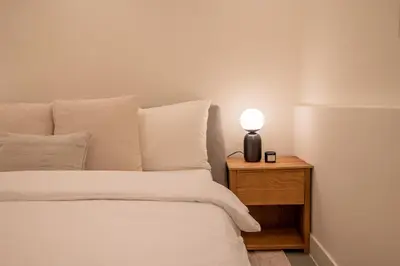 a bed with a nightstand with a lamp on it at Elegant & unique canal house in famous canal area in Amsterdam
