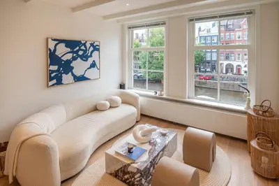 a living room with a couch and two windows at Elegant & unique canal house in famous canal area in Amsterdam
