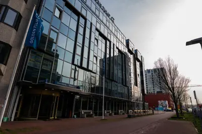 a large building with glass windows on a street at Tulip Inn Leiden Centre in Leiden
