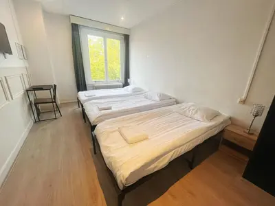 two beds in a room with a window at CoronaZeist-Utrecht NL in Zeist
