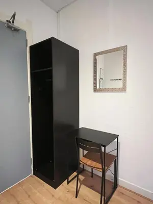 a black cabinet with a table and a mirror at CoronaZeist-Utrecht NL in Zeist