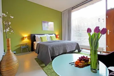 a bedroom with a bed and a table with flowers at Eastendroom in Amsterdam