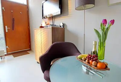 a glass table with a bowl of fruit and a bottle of wine at Eastendroom in Amsterdam