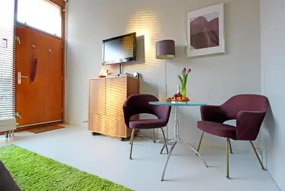 a room with a table and two chairs and a television at Eastendroom in Amsterdam