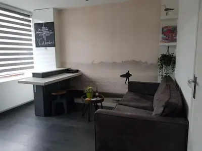 a living room with a couch and a table at Zomerhuisje 18K - 1 km van het strand in Wijk aan Zee