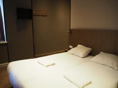 a bedroom with a large white bed with two pillows at Aston City Hotel in Amsterdam
