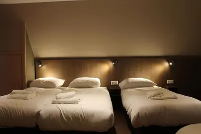 two beds in a hotel room with white pillows at Aston City Hotel in Amsterdam