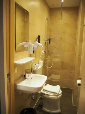 a bathroom with a toilet and a sink and a shower at Aston City Hotel in Amsterdam