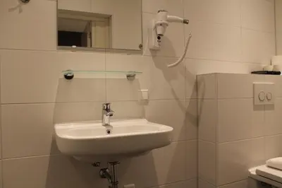 a bathroom with a sink and a mirror at Aston City Hotel in Amsterdam