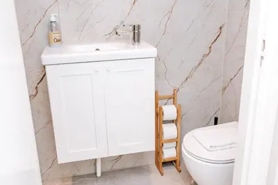 a bathroom with a white sink and a toilet at Appartement Babette in Zandvoort