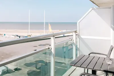 a balcony with a bench and the beach at Appartement Babette in Zandvoort
