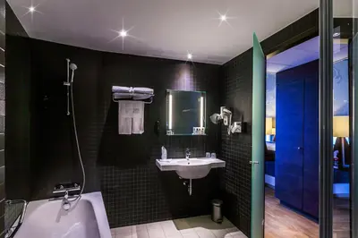 a bathroom with a sink and a tub and a toilet at Hotel Artemis Amsterdam in Amsterdam