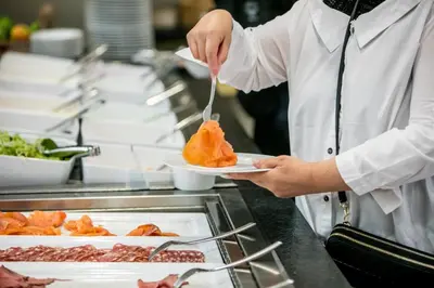 a chef is holding a plate of food at Hotel Artemis Amsterdam in Amsterdam