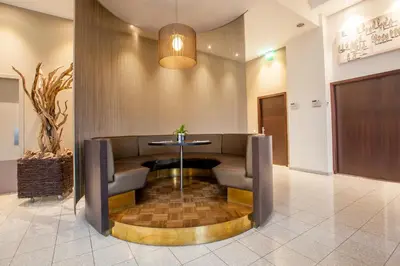 a waiting area with a table and chairs in a lobby at Hotel Artemis Amsterdam in Amsterdam