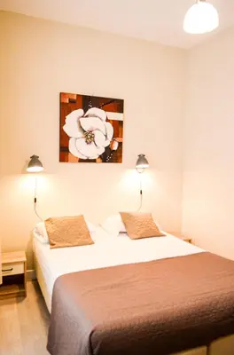 a hotel room with a bed and a flower painting on the wall at Family Hotel Kooyk in Amsterdam