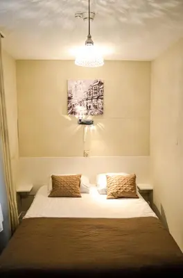 a bedroom with a bed with white sheets at Family Hotel Kooyk in Amsterdam