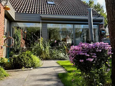 a house with purple flowers in the front yard at 