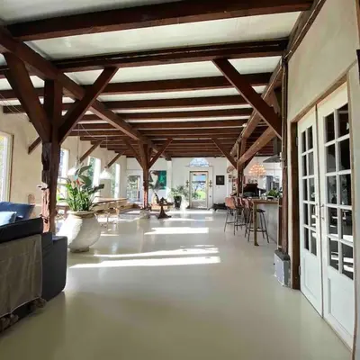 a large room with wooden ceilings and tables and chairs at Farmhouse bohemian style close to Amsterdam in Waverveen