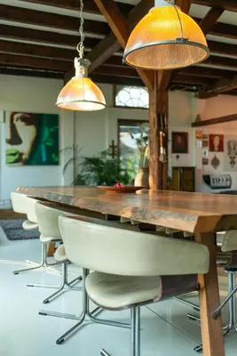 a dining room with a wooden table and chairs at Farmhouse bohemian style close to Amsterdam in Waverveen