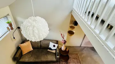 a living room with a couch and a pendant light at Duynbossie in Schoorl