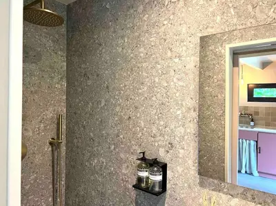 a bathroom with two bottles on a shelf next to a mirror at Duynbossie in Schoorl
