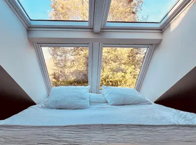 a bed in a room with a large window at Duynbossie in Schoorl