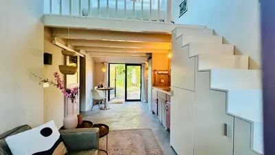 a living room with a staircase in a house at Duynbossie in Schoorl