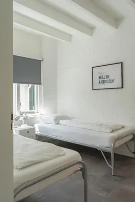 a room with two beds and a sign on the wall at -Casa Branca- nabij het meer, strand en keukenhof in Noordwijkerhout