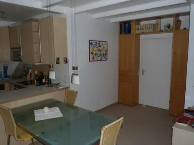 a kitchen with a table and a door to a kitchen at Sterflat 39 in Egmond aan Zee