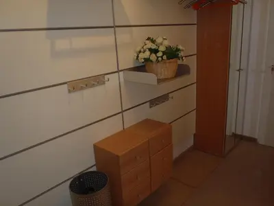 a room with a dresser and a plant on a wall at Sterflat 39 in Egmond aan Zee