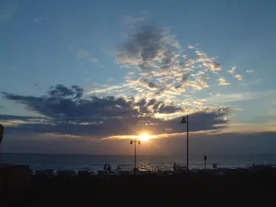 a sunset on the beach with the sun setting at Sterflat 39 in Egmond aan Zee