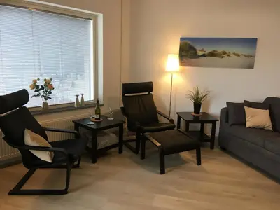 a living room with two chairs and a couch at Sterflat 45 in Egmond aan Zee