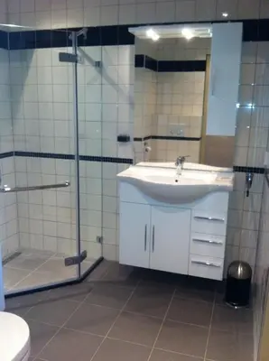 a bathroom with a sink and a shower at Sterflat 45 in Egmond aan Zee