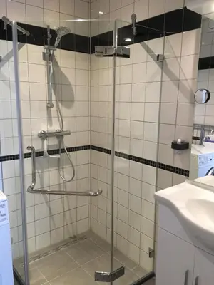a shower with a glass door in a bathroom at Sterflat 45 in Egmond aan Zee