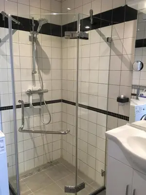 a shower with a glass door in a bathroom at Sterflat 45 in Egmond aan Zee