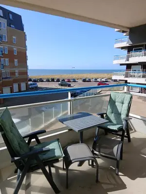a patio with two chairs and a table on a balcony at Sterflat 53 in Egmond aan Zee