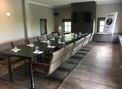 a conference room with a long table and chairs at Fletcher Boutique Hotel Duinoord in Wassenaar