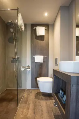 a bathroom with a toilet and a sink and a shower at Fletcher Boutique Hotel Duinoord in Wassenaar