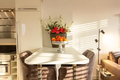 a table with a vase of flowers and fruit on it at Spacious private apartement, 25min from Amsterdam in Hilversum