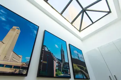 a group of pictures on a wall with a window at Spacious private apartement, 25min from Amsterdam in Hilversum