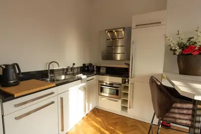 a kitchen with white cabinets and a sink and a counter at Spacious private apartement, 25min from Amsterdam in Hilversum