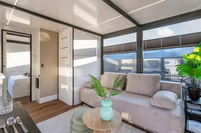 a living room with a couch and a table at Charming Tiny Houseboat Escape Near Amsterdam by Weltevreden Experience in Kortenhoef