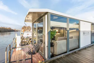 a house on a boat on the water at Charming Tiny Houseboat Escape Near Amsterdam by Weltevreden Experience in Kortenhoef
