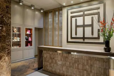 a lobby with a counter with a vase of flowers at The College Hotel Amsterdam, Autograph Collection in Amsterdam