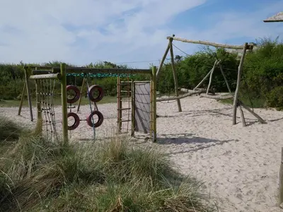 an empty swing set on a sandy beach at Huize de Duinen in Bergen aan Zee
